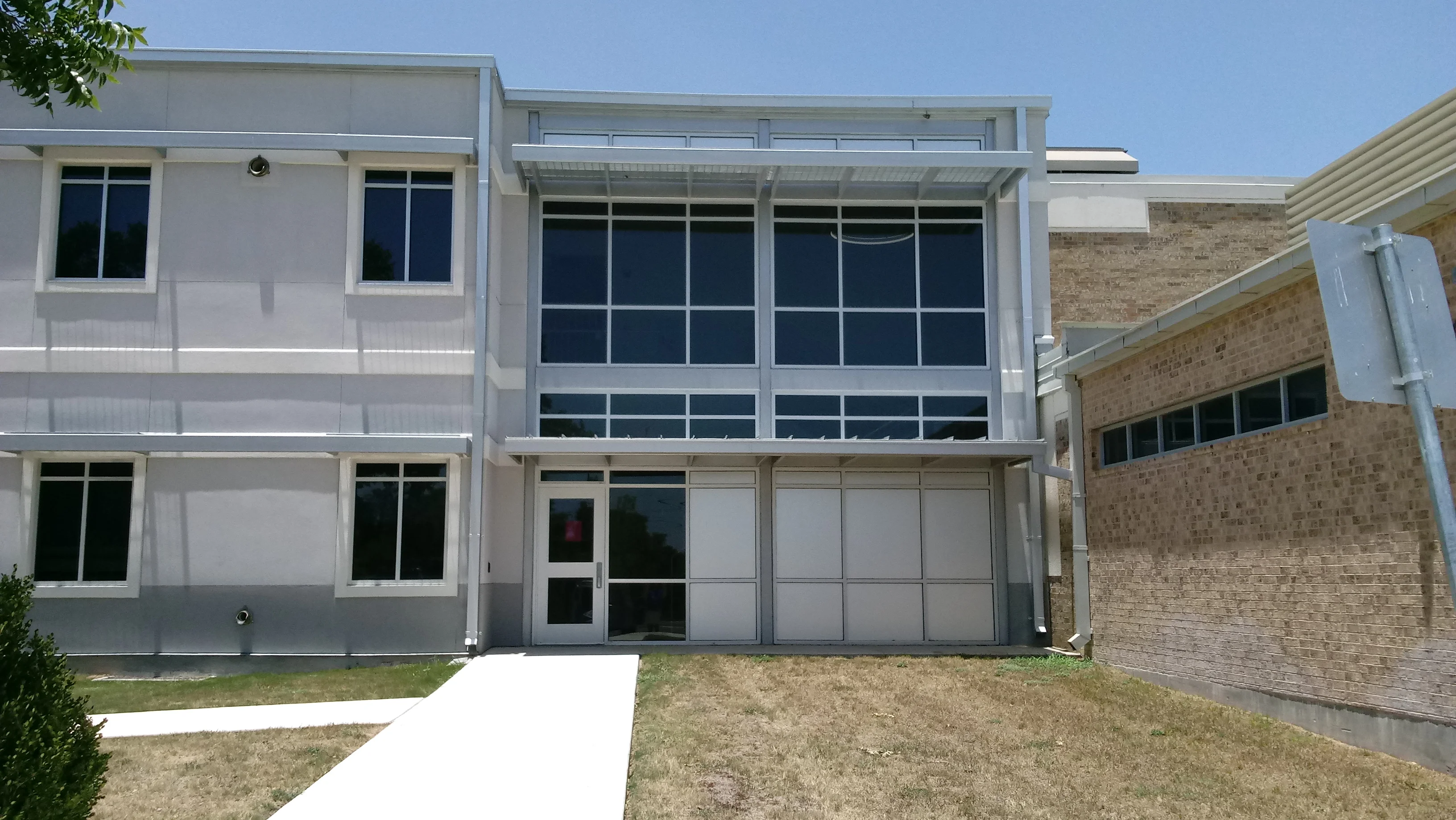 Solar screens installed on commercial building windows with aluminum frames and grid pattern