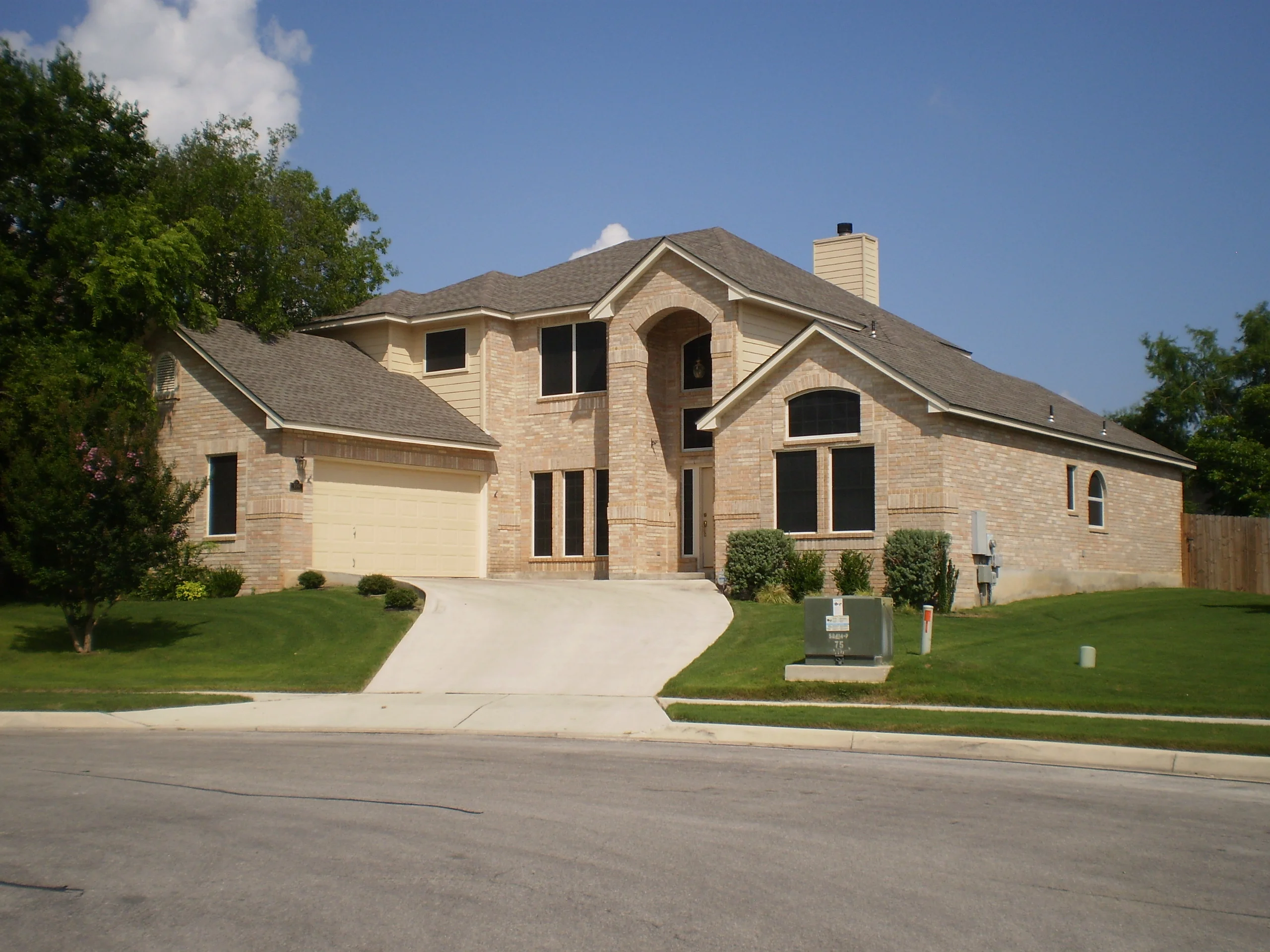 Two-story brick home with newly installed windows including arched designs and multiple pane configurations