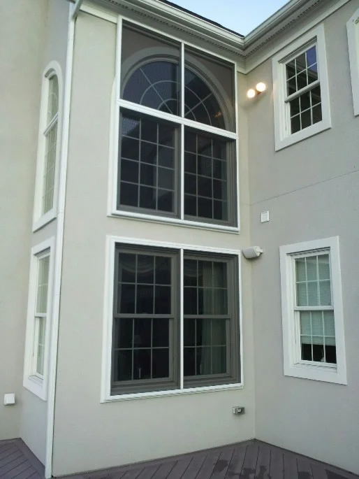 White aluminum stand-off frame windows with dark tinted glass and arched transom detail