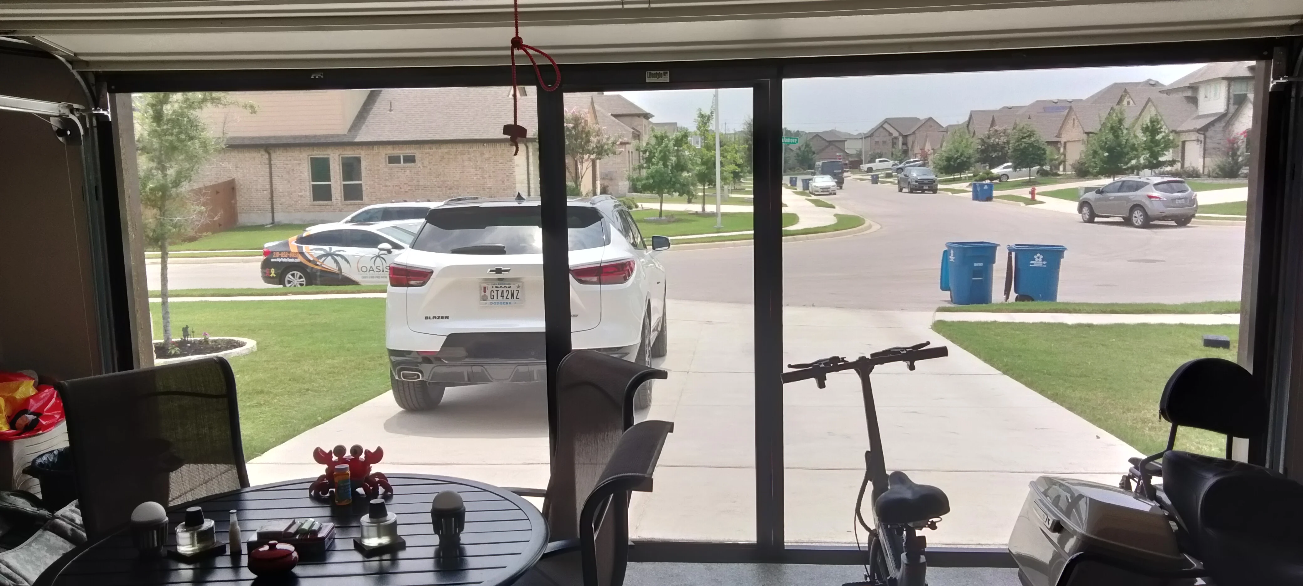 Patio enclosure with solar screens, aluminum framing, and glass sliding doors overlooking driveway