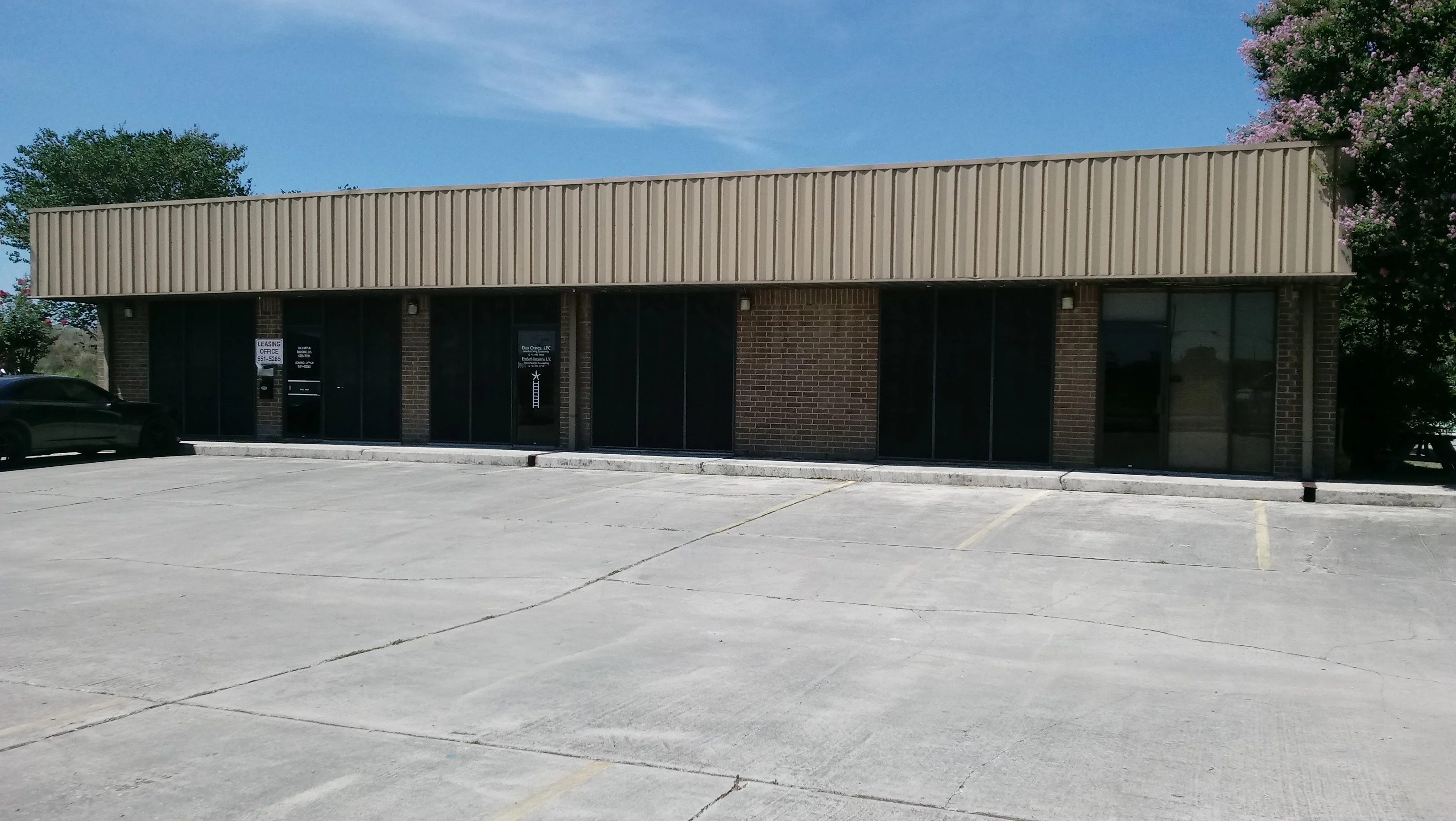 Commercial storefront with black-framed glass doors and windows on brick building facade
