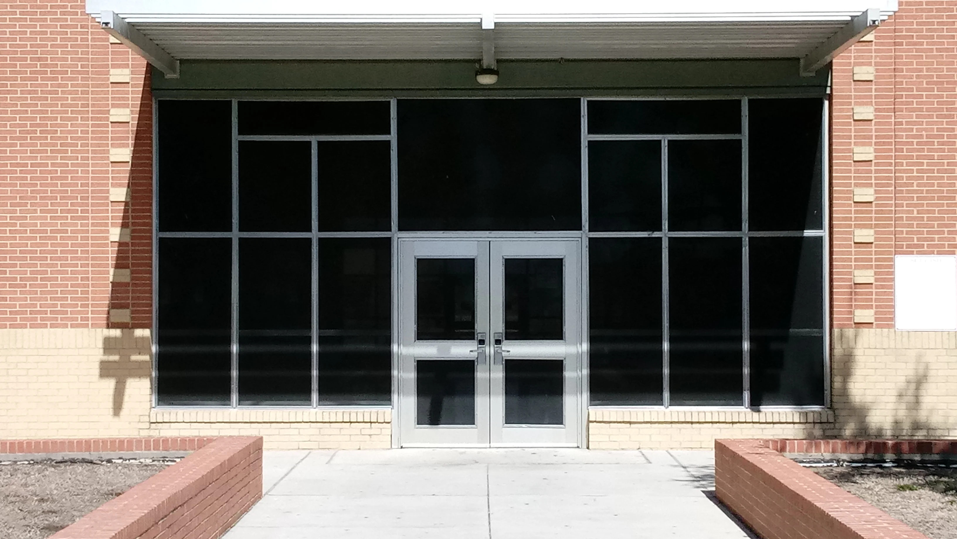 Commercial storefront with aluminum-framed windows and glass double doors on brick building