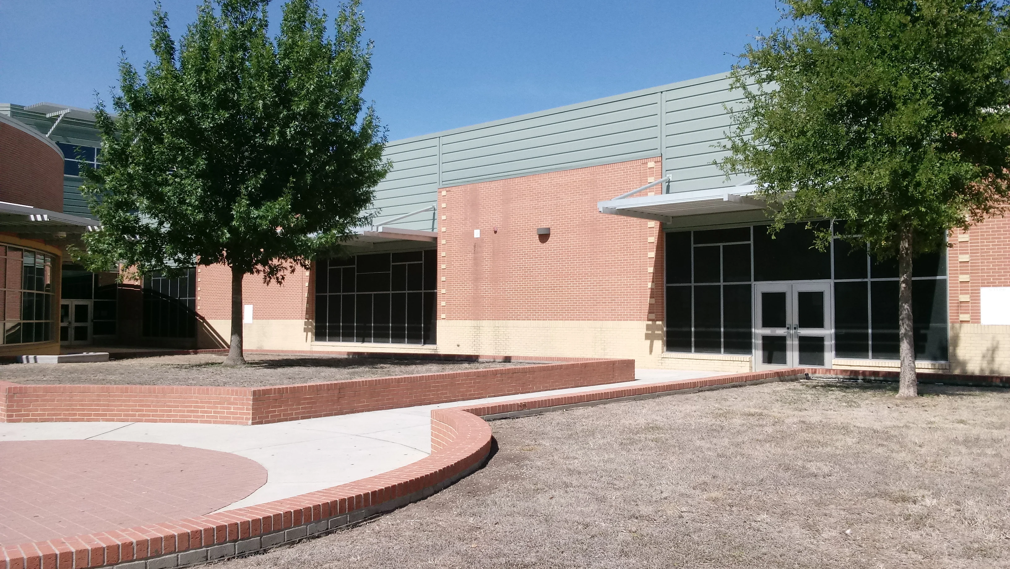 Commercial building with dark-framed storefront windows and glass entry doors in red brick facade