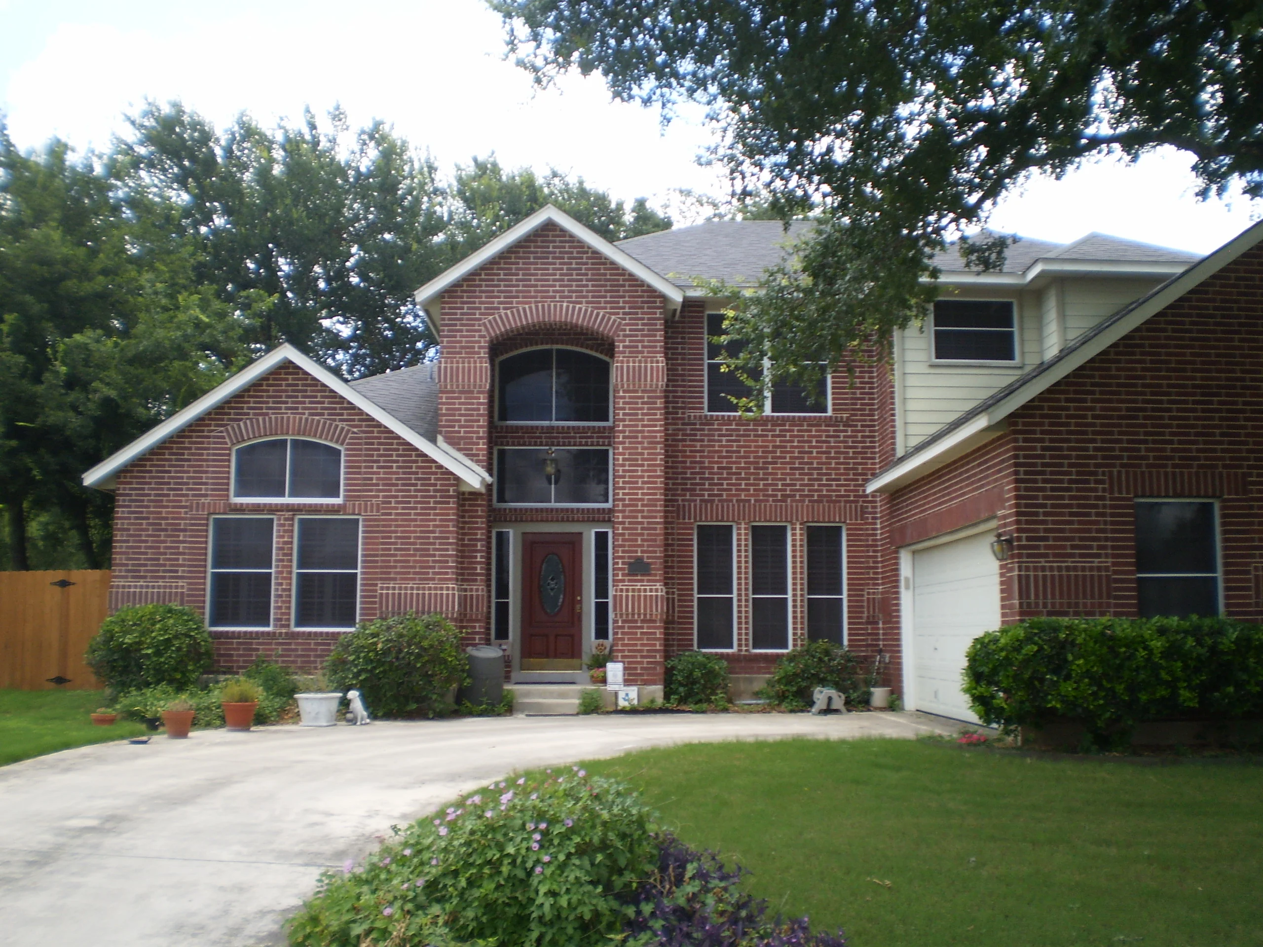 Brick home with multiple replacement windows, arched upper windows, white trim